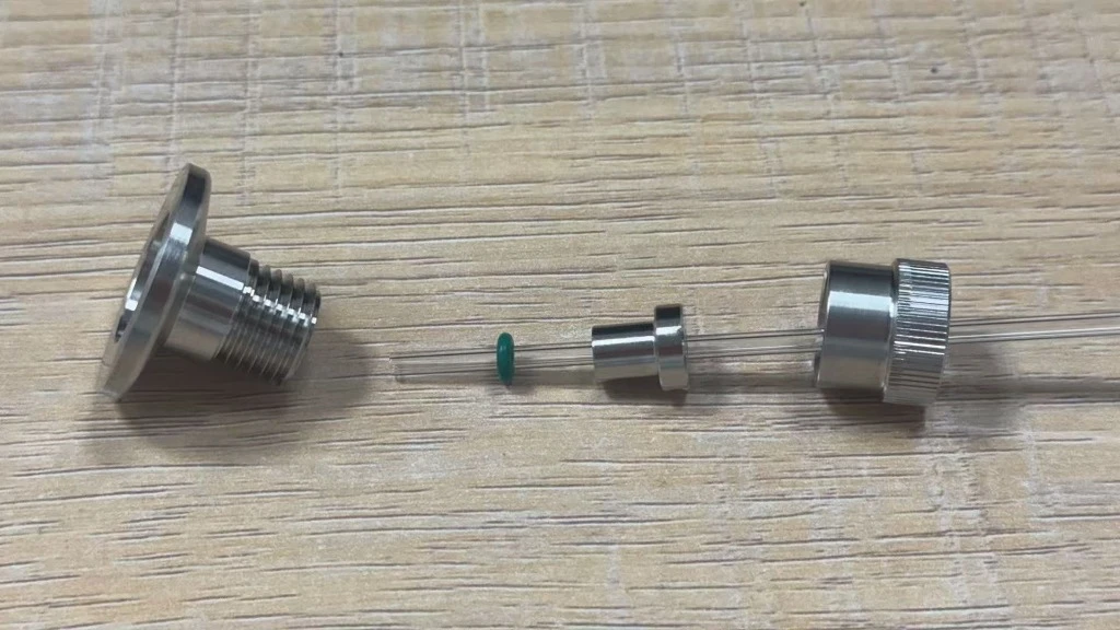 Assembled quartz tube adapter fitting showing thin quartz tube insertion with precision sealing bushing